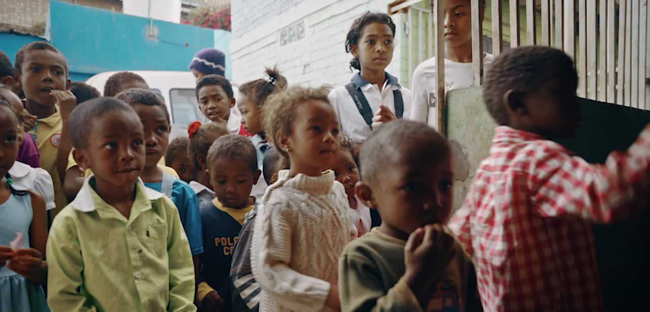 Children gathered at a serving window in Madagascar, from Properly’s project footage
